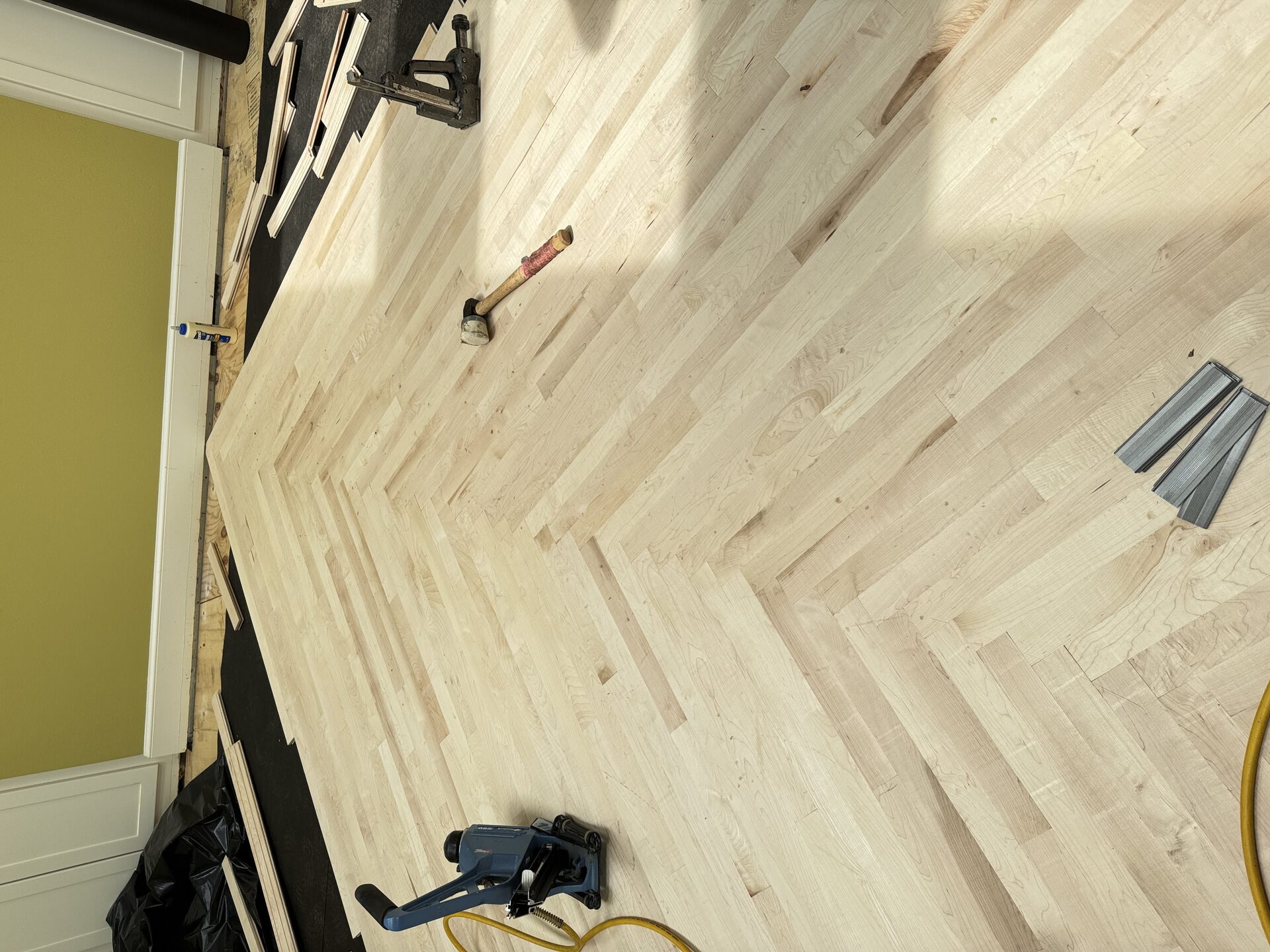 White oak herringbone hardwood floor installation in progress in Northwest Arkansas